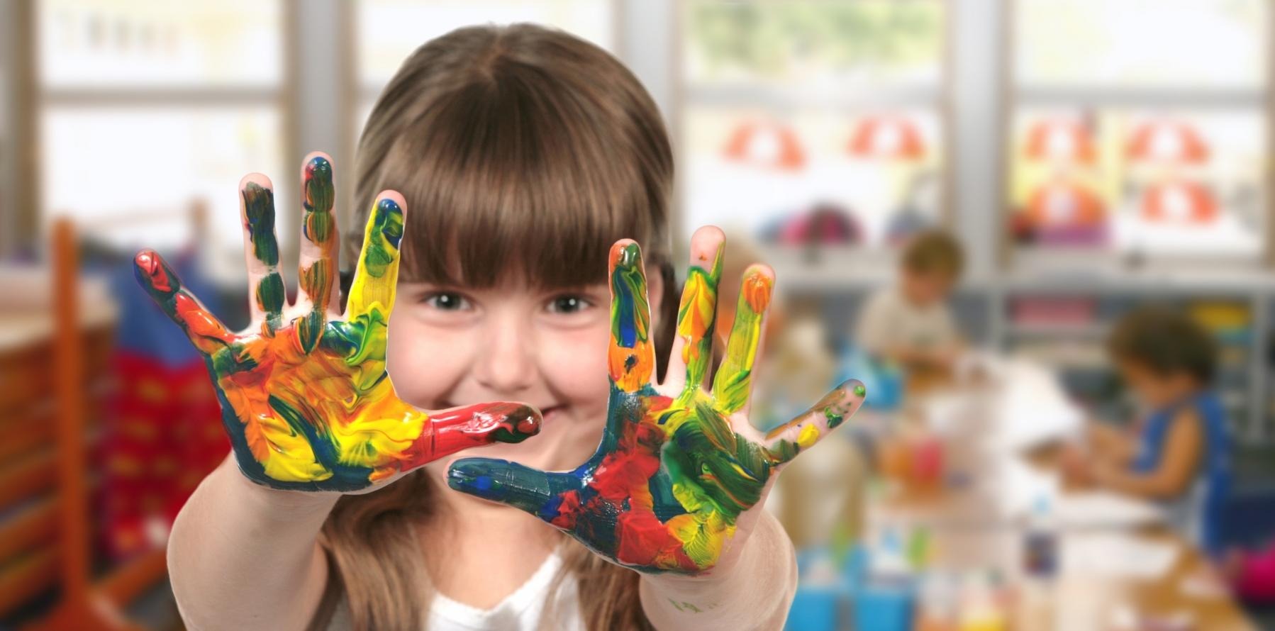 Barn visar upp målade händer, illustrativ bild.