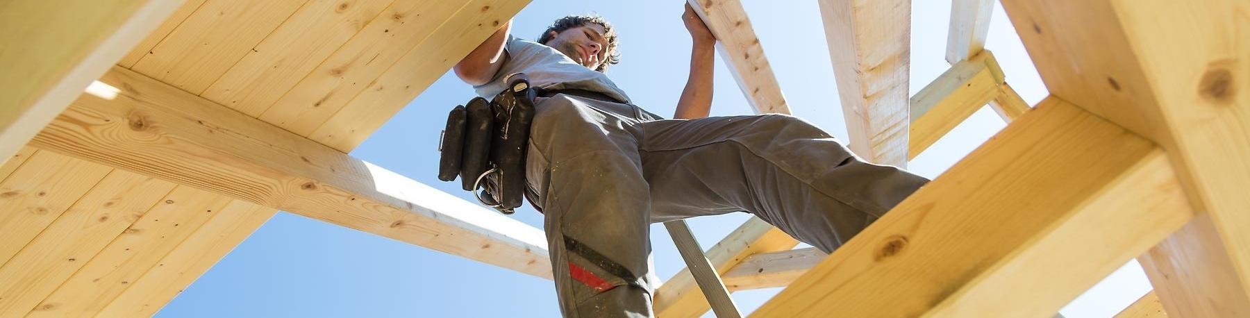Byggarbetare går på reglar på bygge.